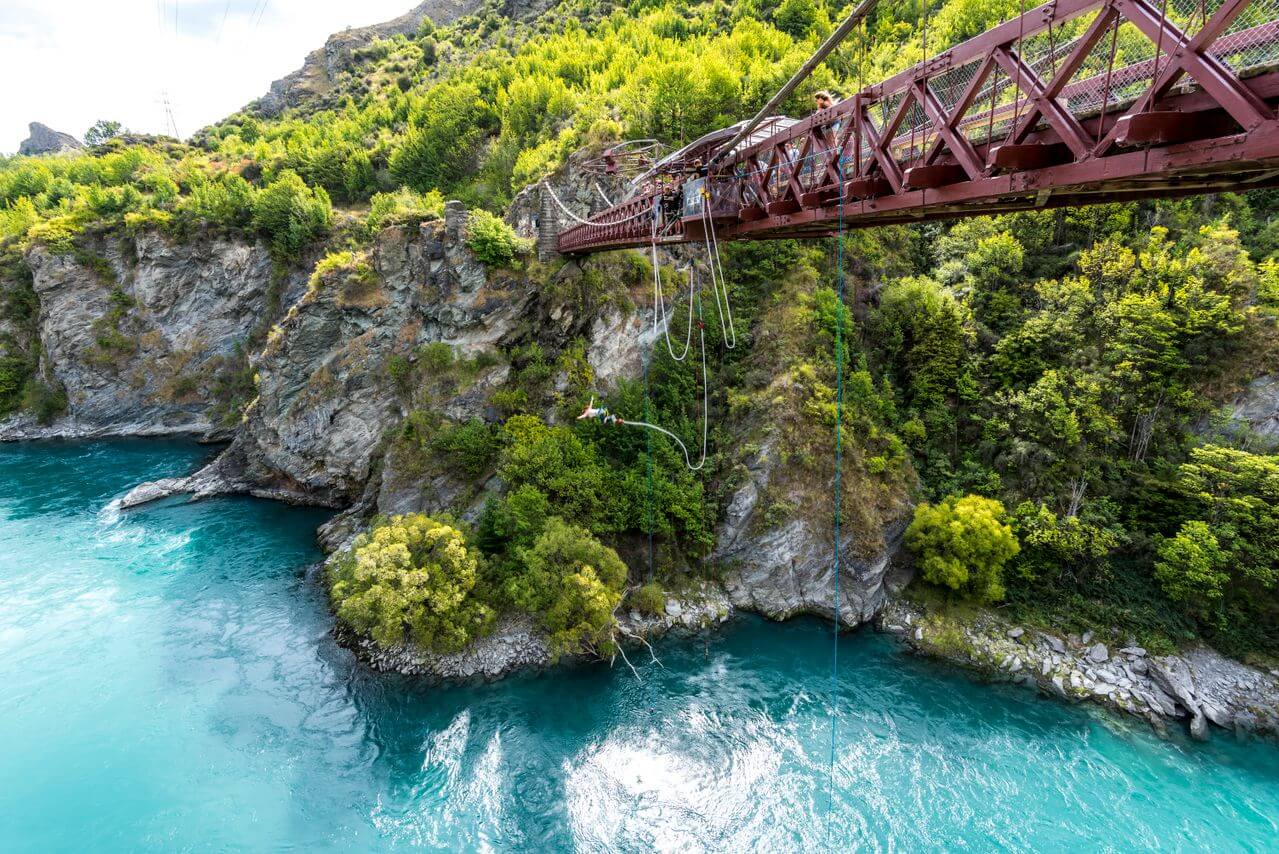 Skok na bungee z mostu Kawarau nad turkusową rzeką w Nowej Zelandii