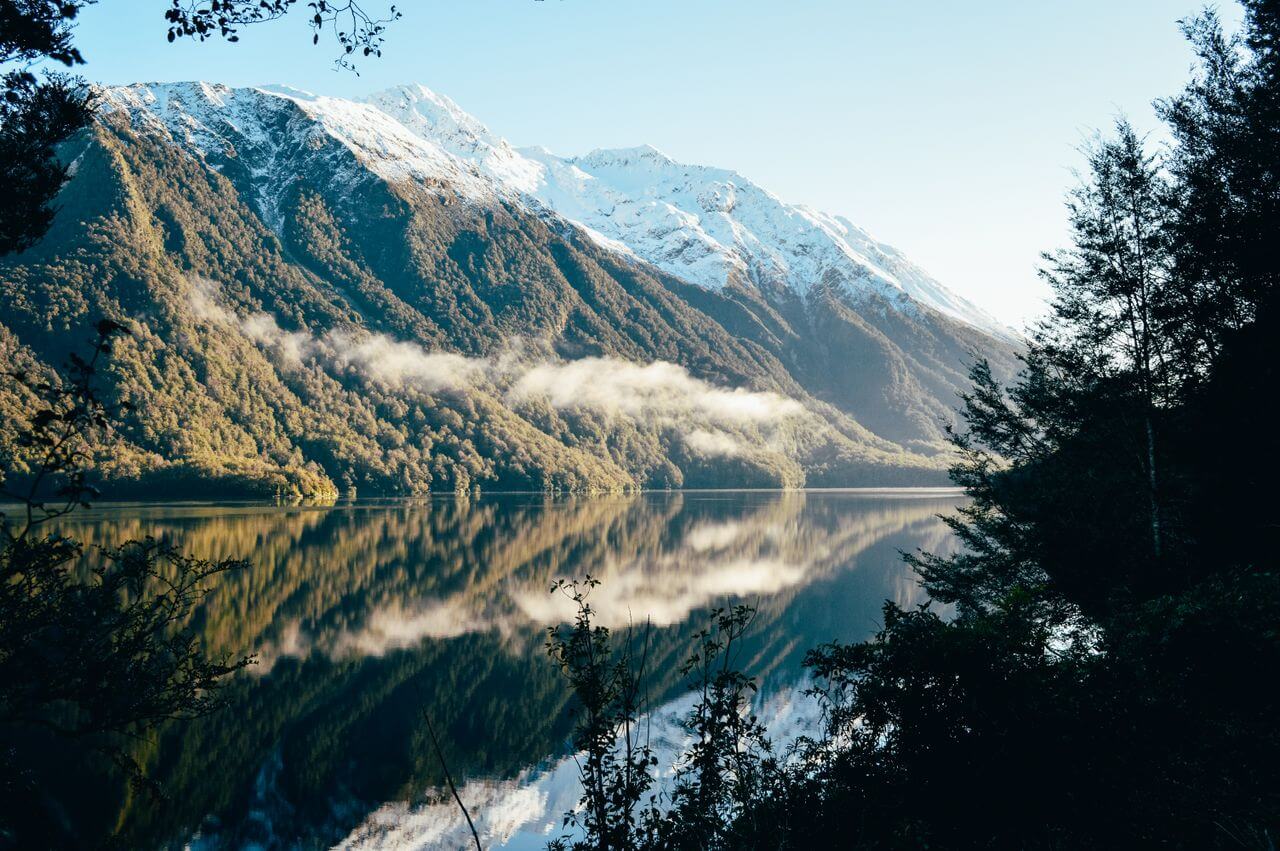 Górskie jezioro otoczone ośnieżonymi szczytami w regionie Fiordland