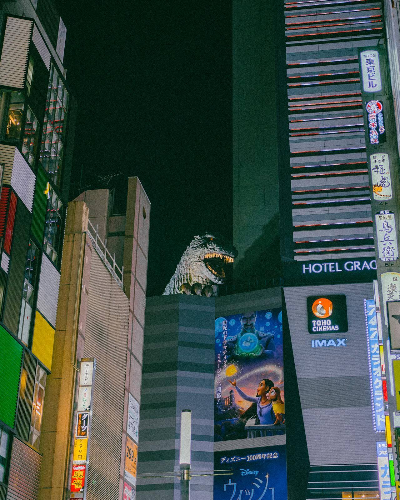 Godzilla nad budynkiem TOHO w nocnym Kabukichō