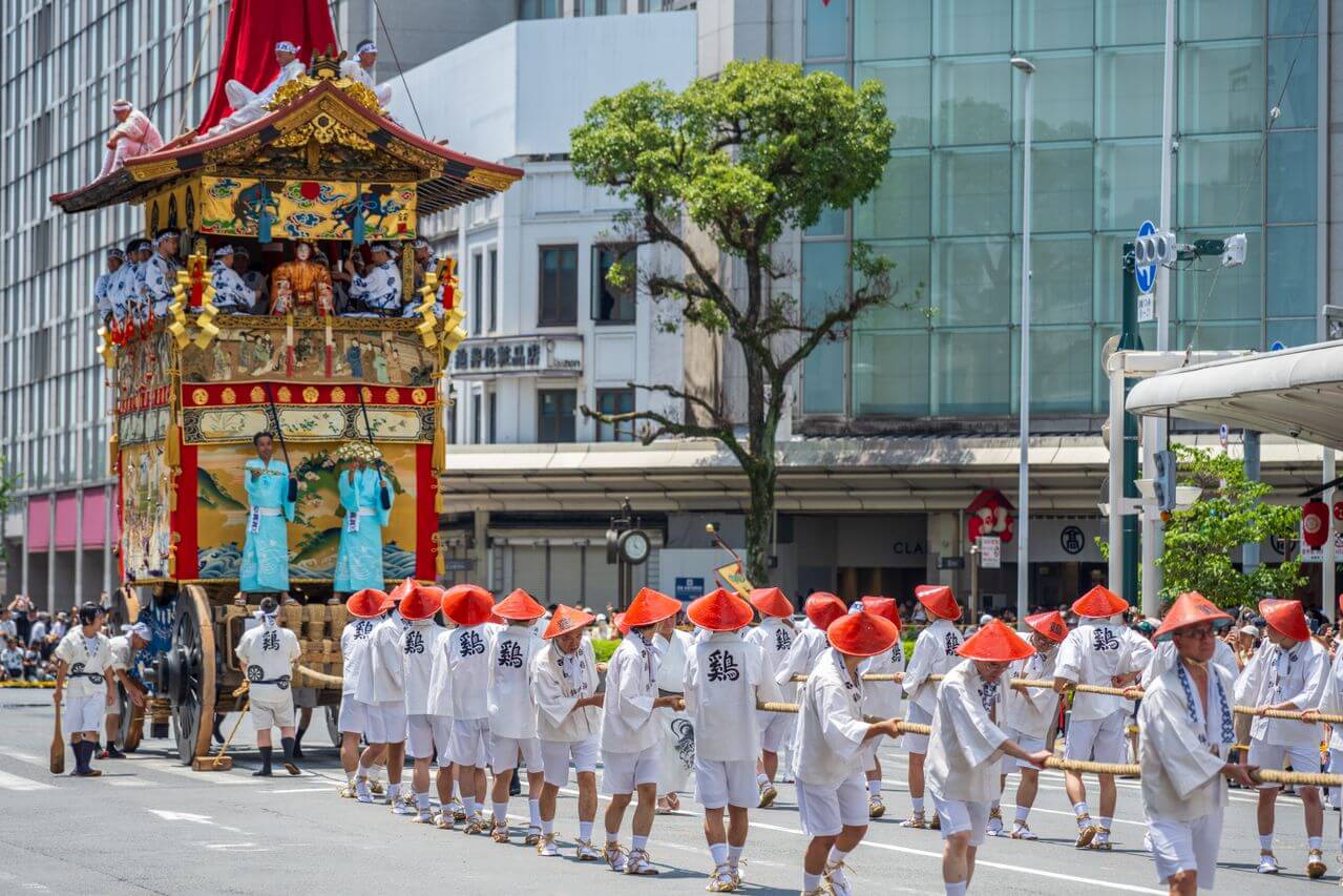 Uczestnicy Gion Matsuri ciągnący monumentalną platformę yamaboko ulicami Kioto