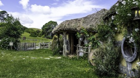 wyprawa do Nowe Zelandii Domek hobbita z krytym strzechą dachem pośród zielonych wzgórz i ogrodu